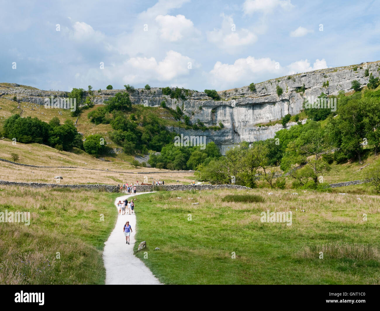 Wanderer auf dem Weg zur Malham Cove, einem Kalkstein geologische Besonderheit in der Yorkshire Dales National Park, England Stockfoto