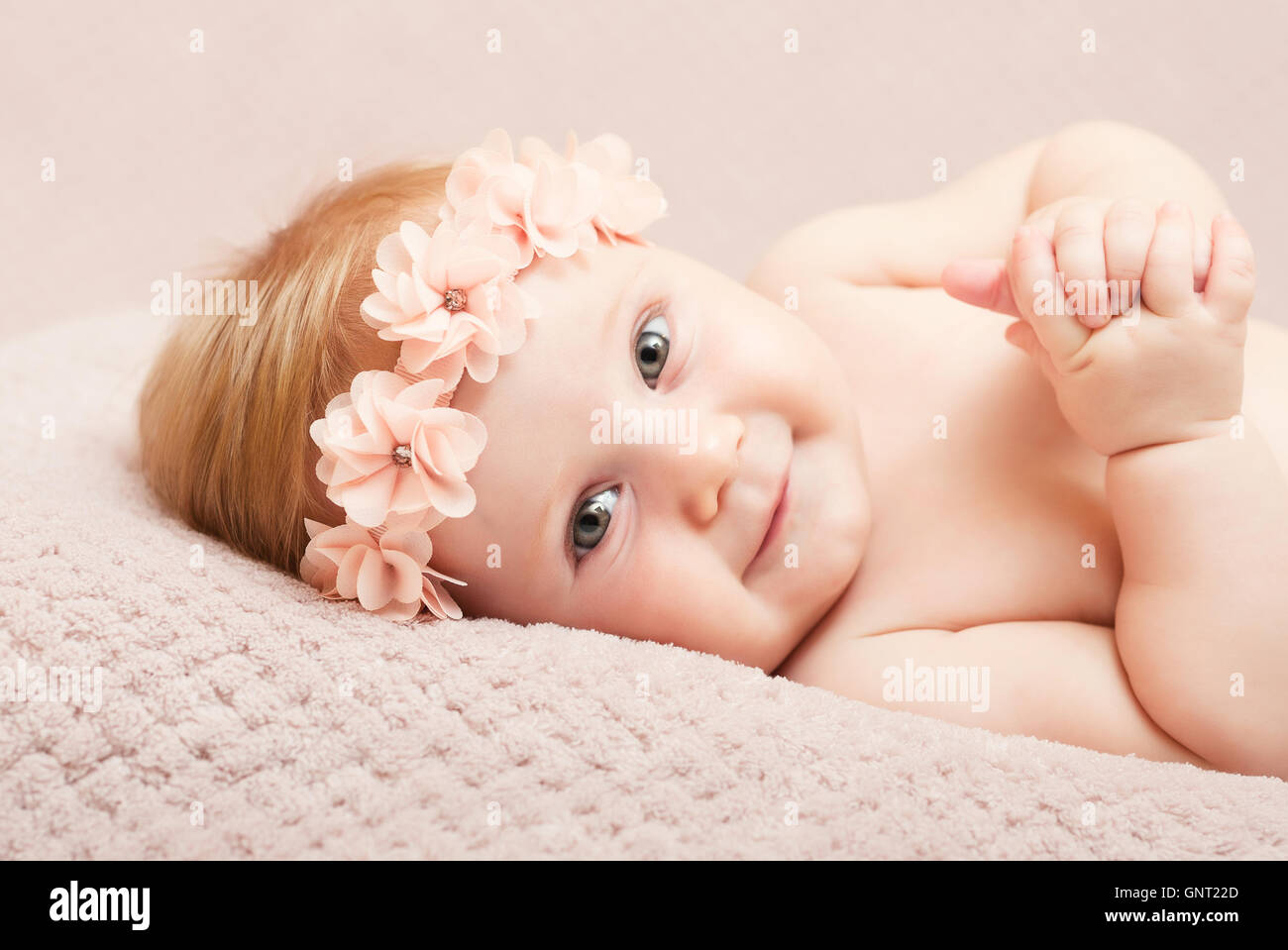 Porträt des kaukasischen Neugeborenen mit rosa Blumen Haarband Stockfoto