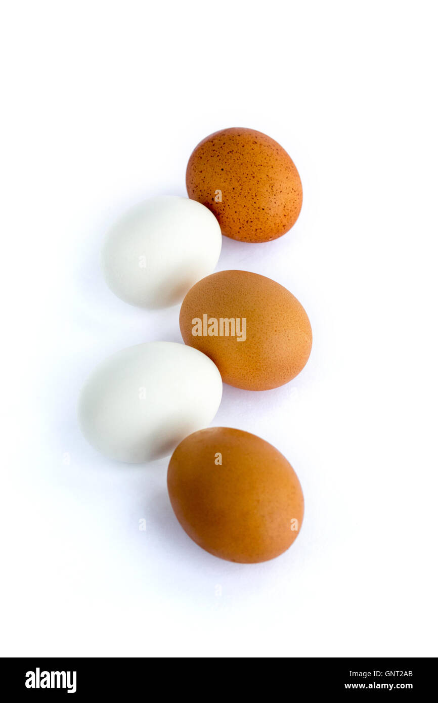 Zusammensetzung der roten und weißen Eiern, die inmitten einer Kette auf weißem Hintergrund Stockfoto