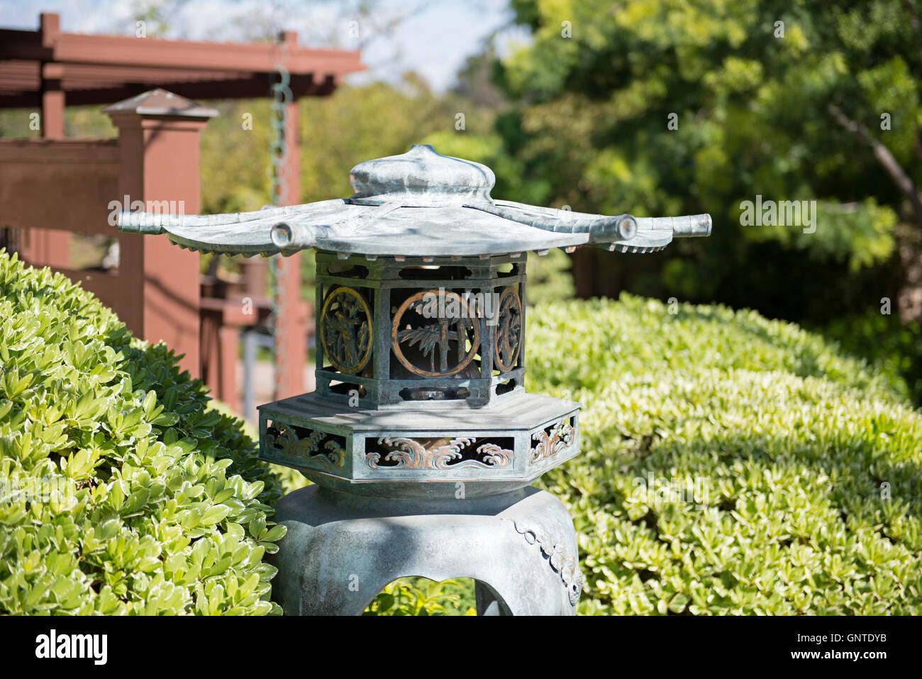 Traditionelle japanische Gartenlaterne aus Metall, umgeben von gepflegtem Grün im Japanischen Freundschaftsgarten im Balboa Park, San Diego. Stockfoto