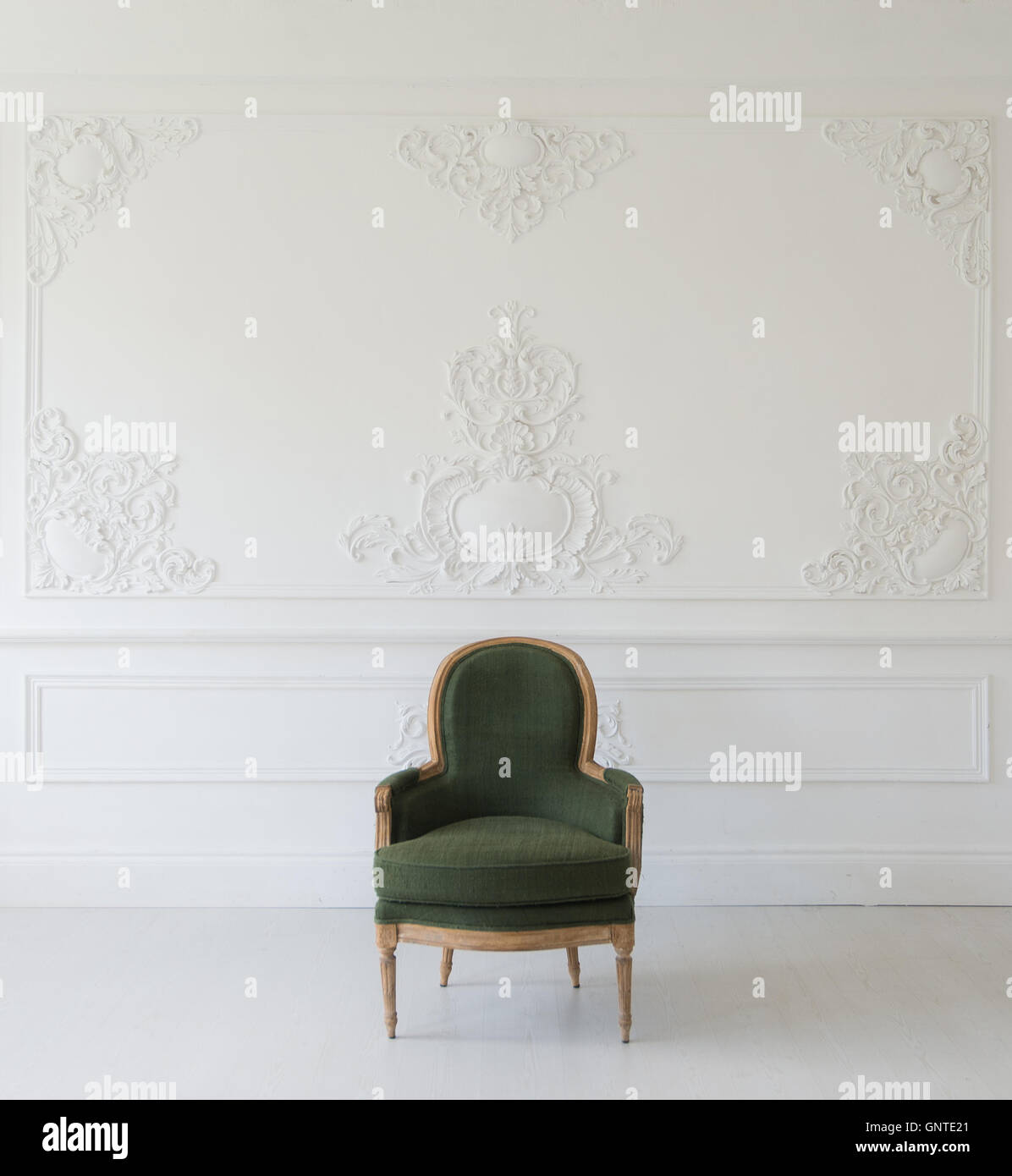 Wohnzimmer mit antiken stilvolle grüne Sessel auf Luxus weiße Wand Basrelief Stuck Zierleisten-Jahrgang Designelemente Stockfoto