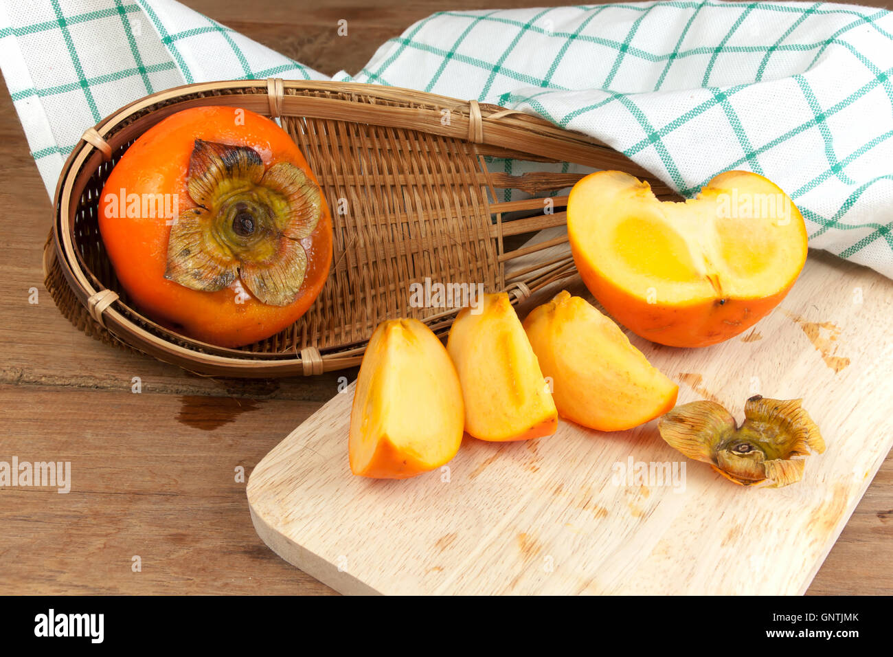 Persimone gelbe Farbe Reife Früchte auf Holztisch aufgeteilt Stockfoto