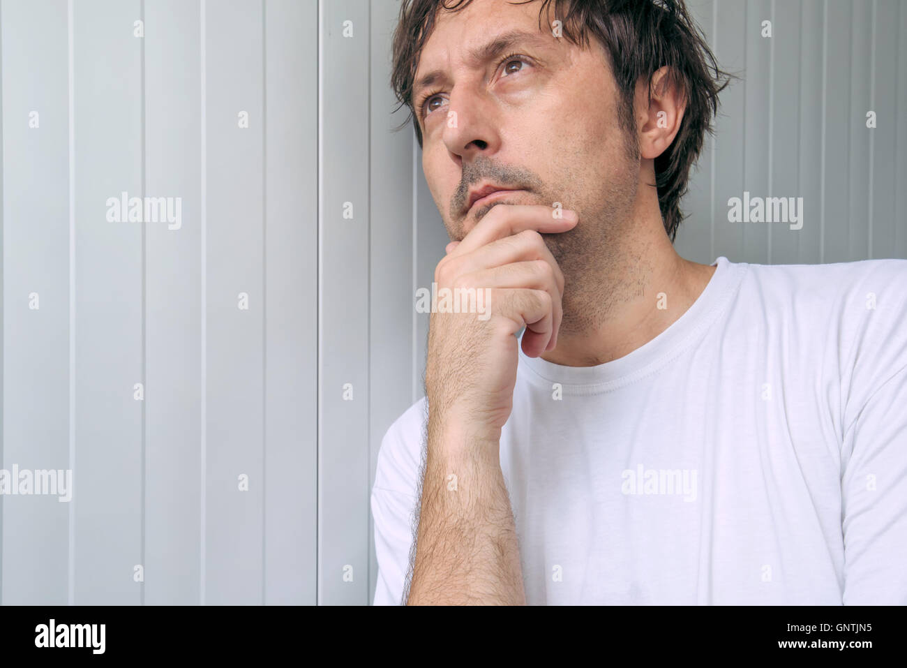 Mann mit Hand am Kinn, tiefe Gedanken und harte Entscheidungen Stockfoto