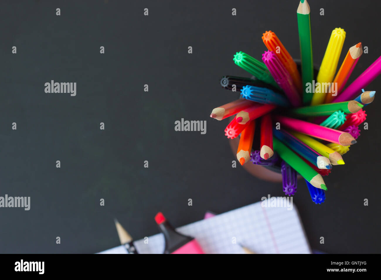 Bunte Stifte auf schwarz Tabelle; Schulmaterial Hintergrund mit Kopie Raum Stockfoto
