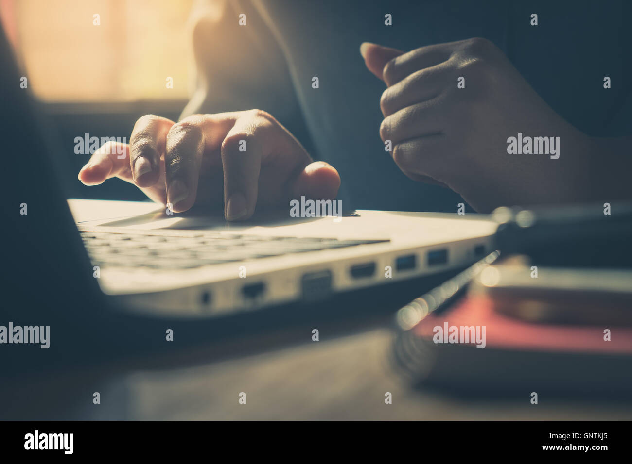 Frau freier Mitarbeiter durch ihre Rechte Hand auf Laptop-Touchpad berühren, etwas auszuwählen, während der Arbeit im Café am Wochentag morni Stockfoto