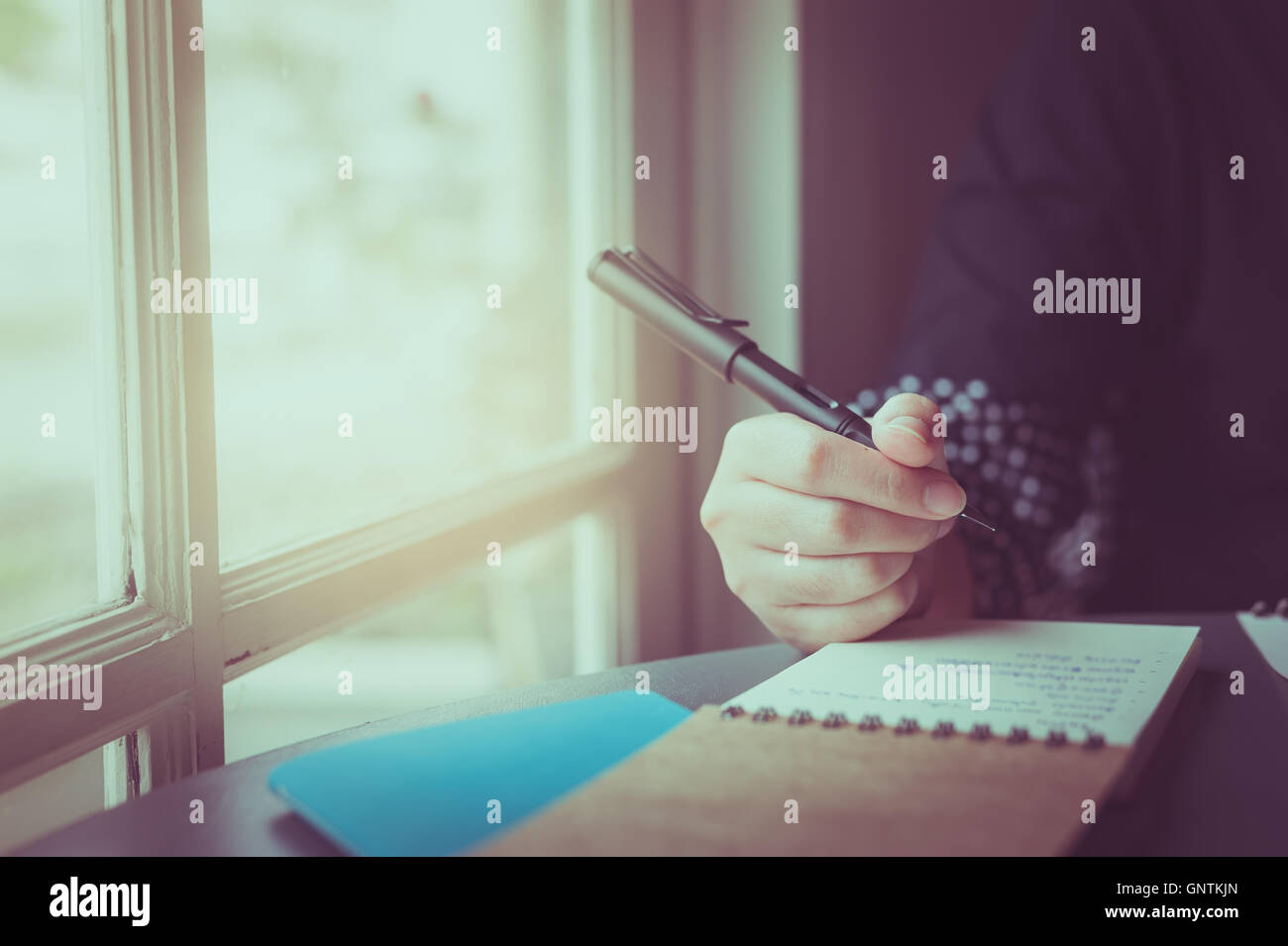 Morgen-Szene junge Hipster Frau rechten Hand schreiben auf kleinen Notebook neben Fenster im Café. Freiberufliche Arbeit Lebensstil Witz Stockfoto