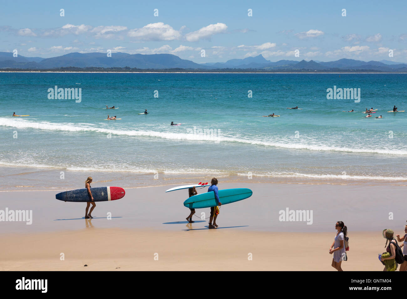 Surfer begeben sich am Sommertag in Byron Bay, New South wales, Australien zu den Wellen am Wategos Beach Stockfoto