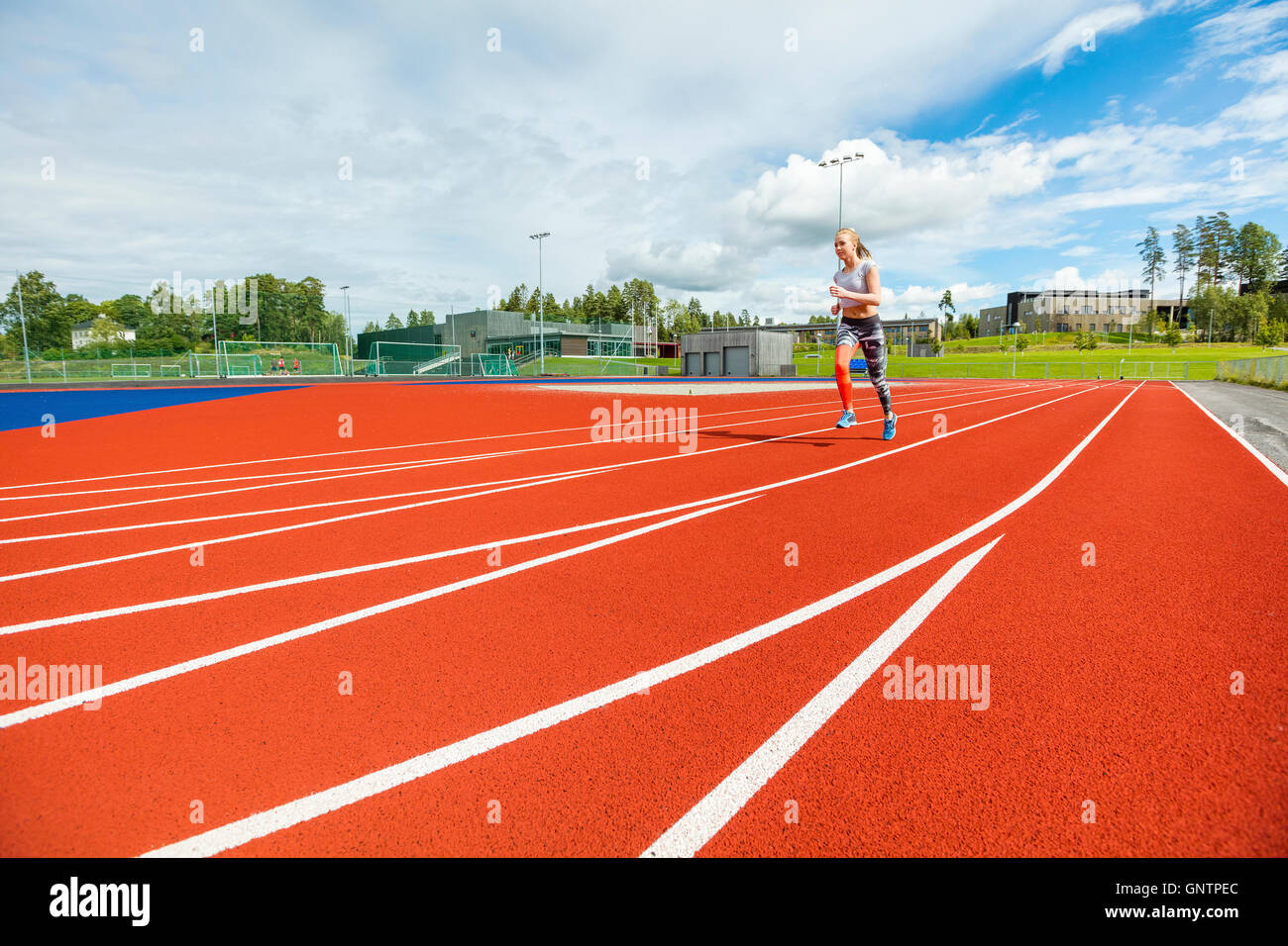 Passen Sie junge Frau läuft auf Sport Tracks Stockfoto