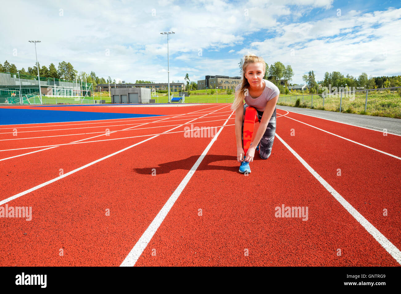 Selbstbewusste Frau, die Schnürsenkel zu binden, auf Laufstrecken Stockfoto