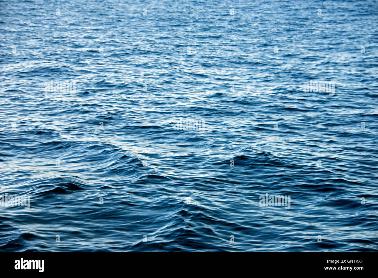 Hintergrund transparent Kristall blaue Meer Wasser Oberfläche Welligkeit mit Reflektion der Sonne im Sommer. Wasser-Hintergrund. Meer Wasser te Stockfoto