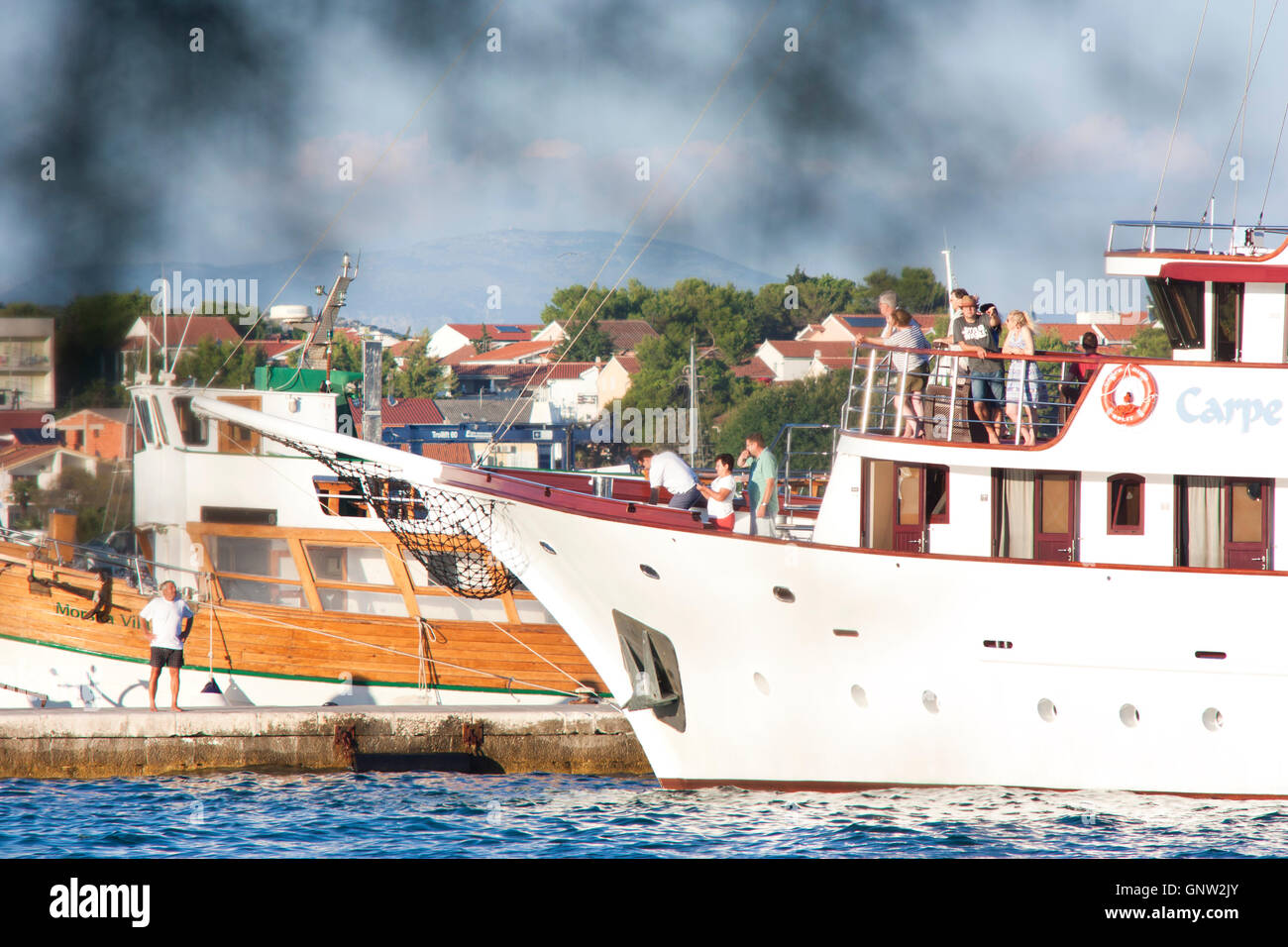 Vodice, Kroatien - 20. August 2016: Ein Kreuzfahrtschiff Carpe Diem kommt in Vodice und bereitet sich auf dock. Ein Mann auf einem Pier ist gerade. Stockfoto