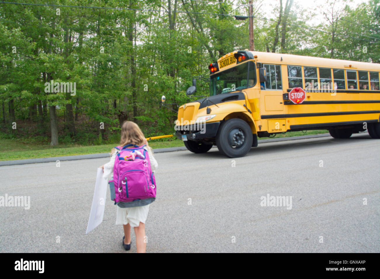 Junges Mädchen wird auf den Schulbus Stockfoto