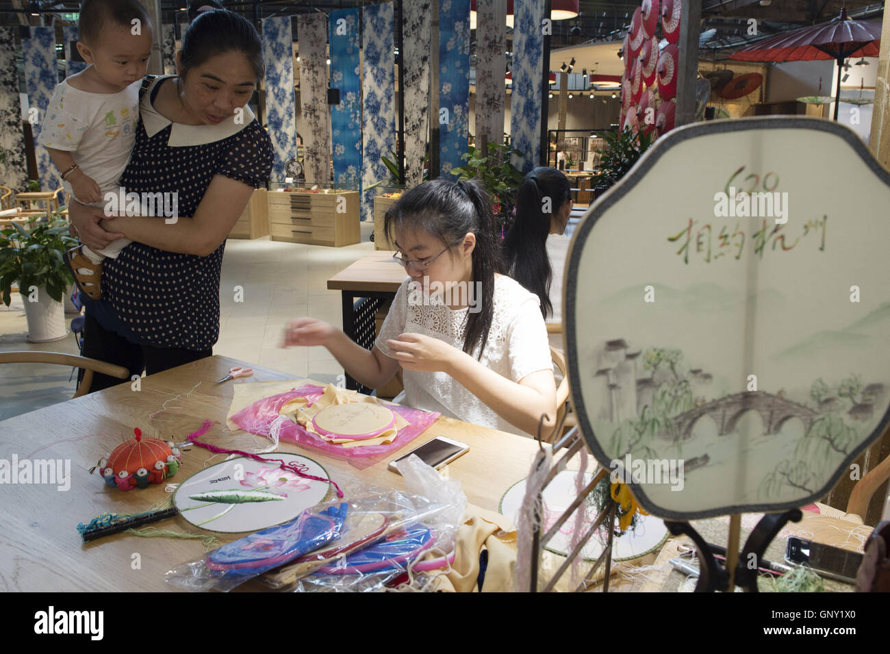 Hangzhou, China Zhejiang Provinz. 1. September 2016. Besucher sehen die Technik der Stickerei im Ausstellungssaal des traditionellen Kunsthandwerks im historischen Qiaoxi Block in der Nähe der Gongchen Brücke in Hangzhou, Hauptstadt der ostchinesischen Provinz Zhejiang, 1. September 2016. Traditionelles Handwerk und lokale immaterielle Kulturerbe wurden dort gezeigt. © Ju Huanzong/Xinhua/Alamy Live-Nachrichten Stockfoto