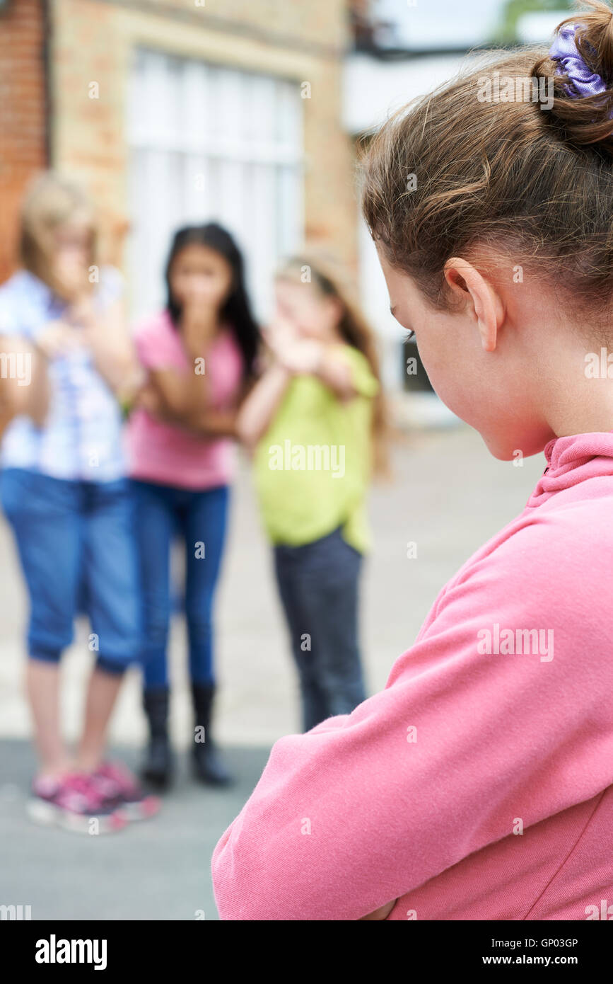 Unglückliche Mädchen wird durch Schulfreunde über geplaudert Stockfoto