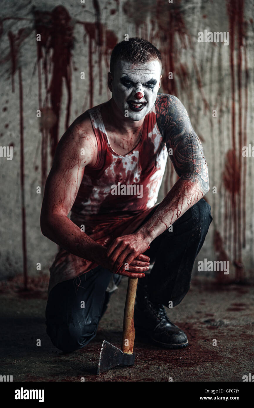 Blutige Clown-Maniac mit Axt Stockfoto