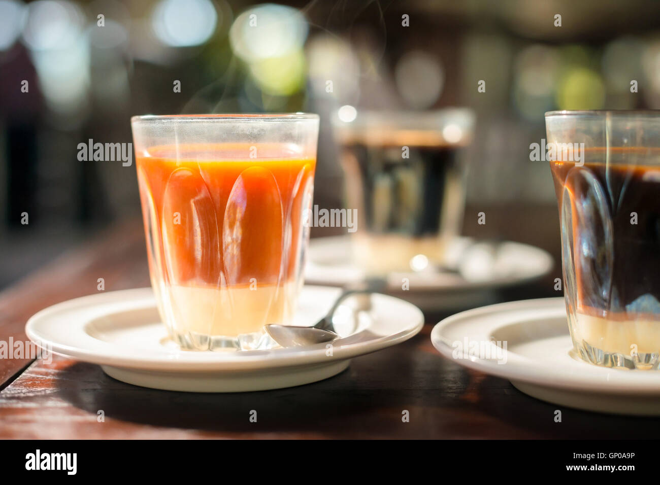 Thai Tradition heißen Tee mit gesüßter Kondensmilch im alten Stil Cup auf Holztisch serviert. Stockfoto