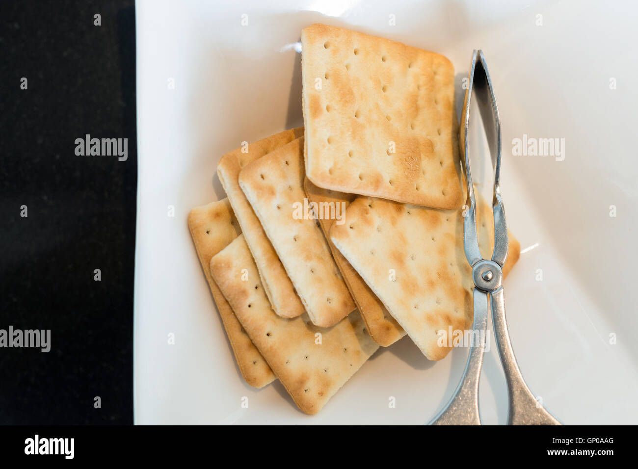 Cracker in weiße Schüssel mit Klemme Essen. Stockfoto