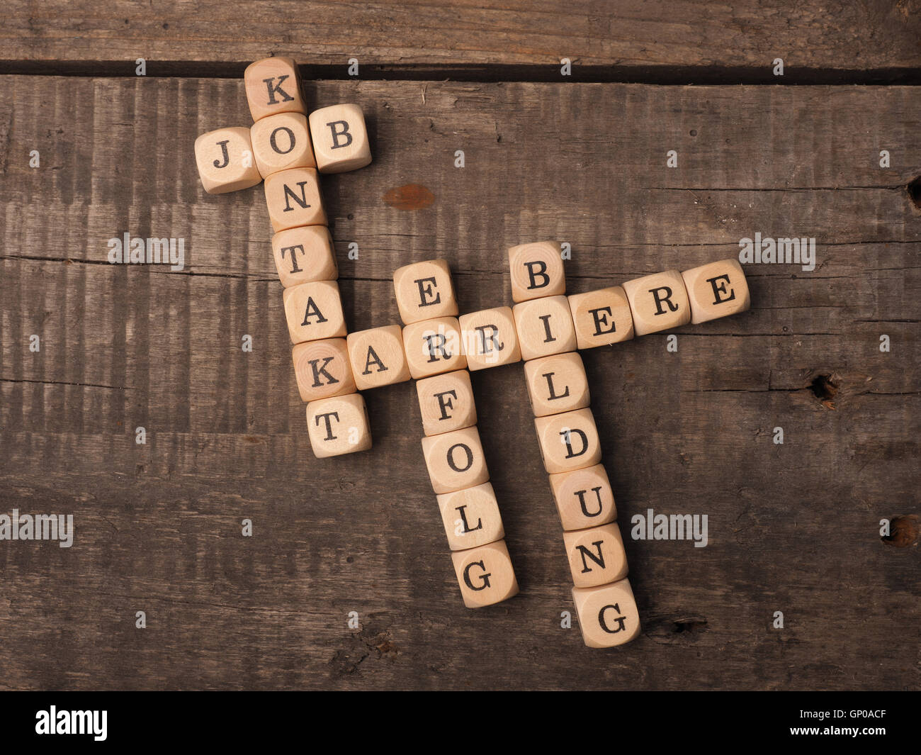 Deutsche Karriere-Konzept mit dem Kreuzworträtsel Karriere, Bildung, Arbeit, Erfolg und Kontakt auf einem rustikalen Holztisch Stockfoto