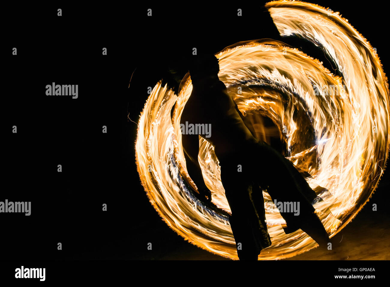ein Mann zeigt Feuer tanzen flammenden Wanderwege. Stockfoto