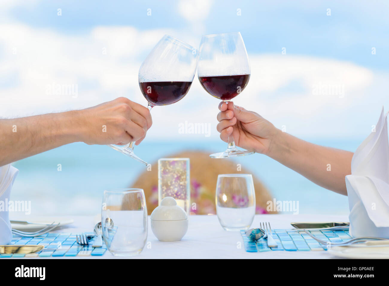 Paar Weintrinken in romantisches Abendessen am Eindunkeln, Nahaufnahme. Tiefenschärfe, geringe Schärfentiefe. Stockfoto
