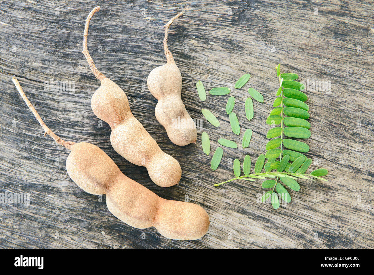 Tamarinde und Blätter auf Grunge Holzbrett. Stockfoto