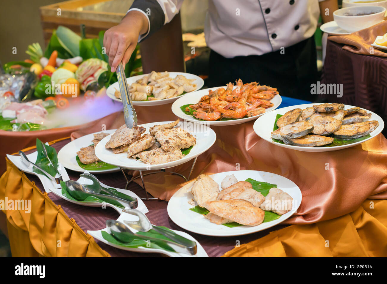 Koch, Abendessen in einem Luxusrestaurant Platten von verschiedenen Fleisch, Schweinefleisch, Rindfleisch, Huhn, Fisch, Garnelen und Tintenfisch vorbereiten. Stockfoto