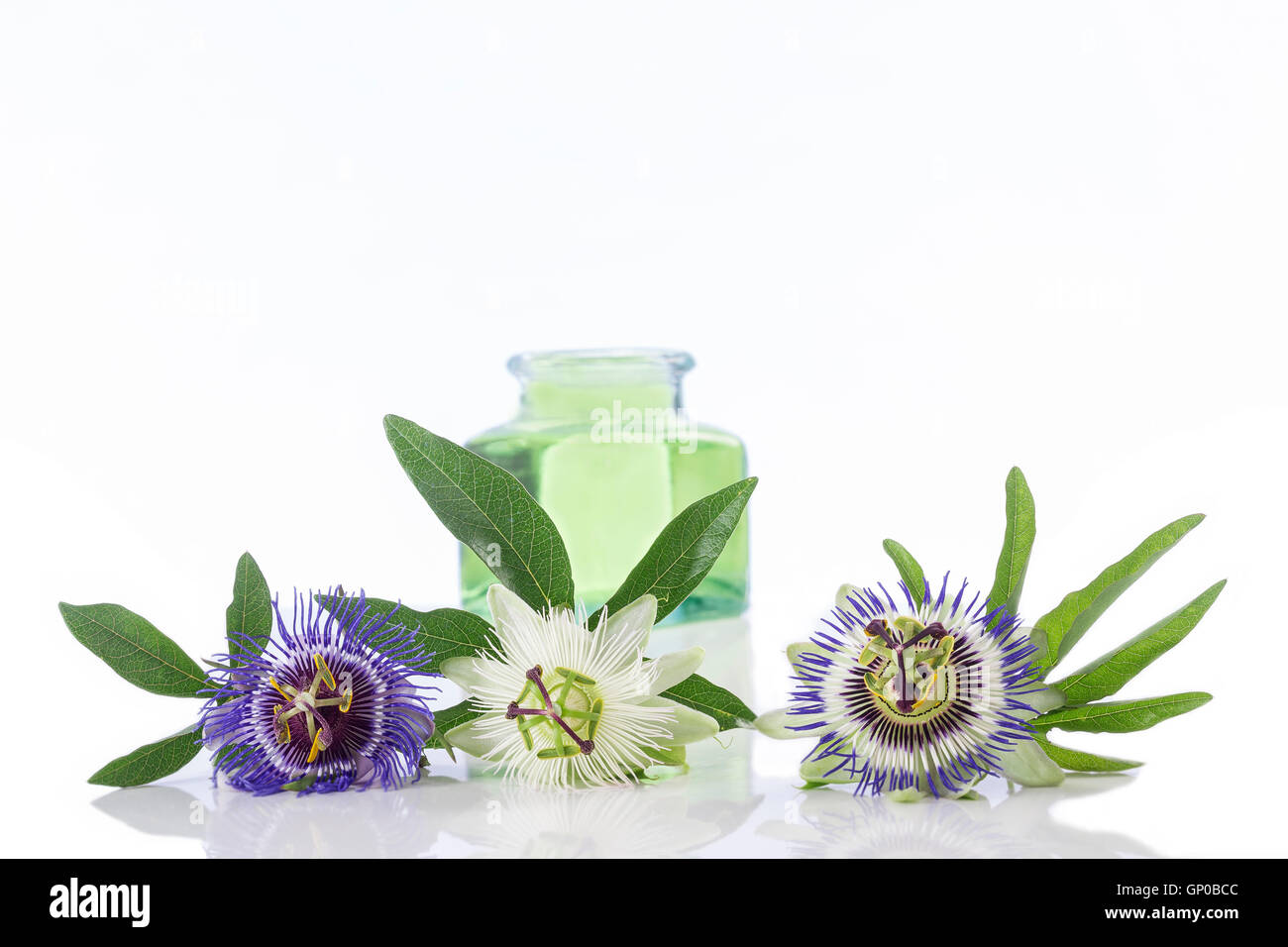 Passionsblume mit Aromatherapie ätherische Öl blau Glas Abfüller isoliert auf weißem Hintergrund. Stockfoto
