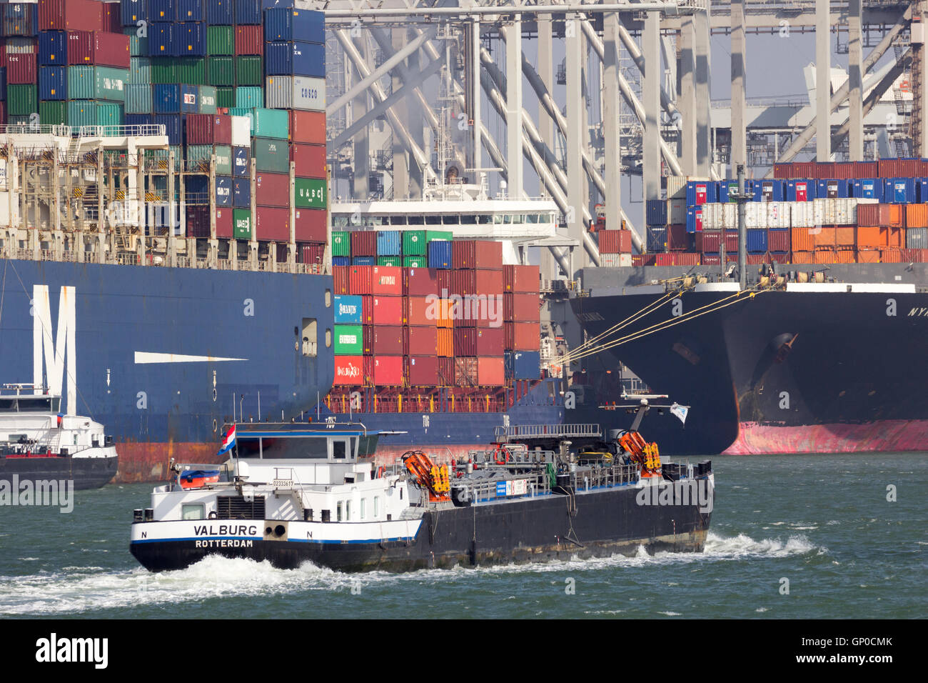 Binnenschiff vorbei Ozean-Container-Schiffe in den Hafen von Rotterdam. Stockfoto