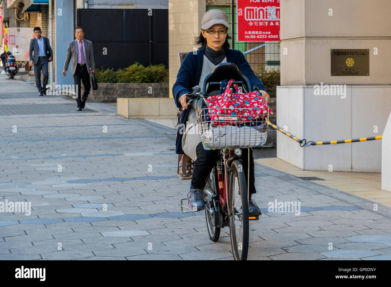 Mutter mit Kind Radfahren in der Stadt Osaka Japan Radwegen, die in der Regel vom Straßenverkehr getrennt gehalten werden Stockfoto