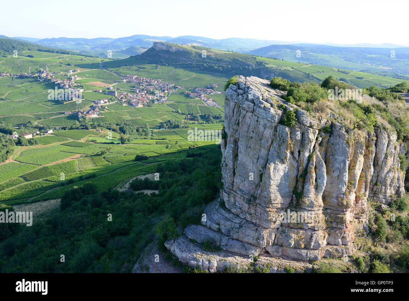 LUFTAUFNAHME. Isolierte Kalksteinklippe mit Blick auf eine Landschaft von Weinbergen. La Roche de Solutré, Saône-et-Loire, Burgund, Frankreich. Stockfoto