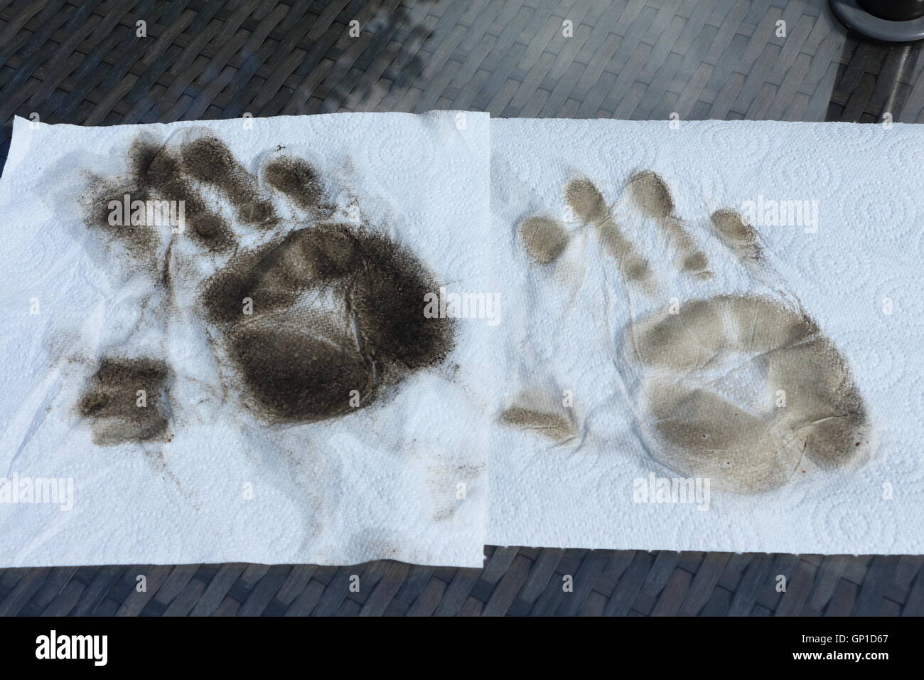 Zwei schmutzige Handabdrücke auf weißen Küchenpapier nach der Reinigung der Glasplatte des Tisches Terrasse. Stockfoto