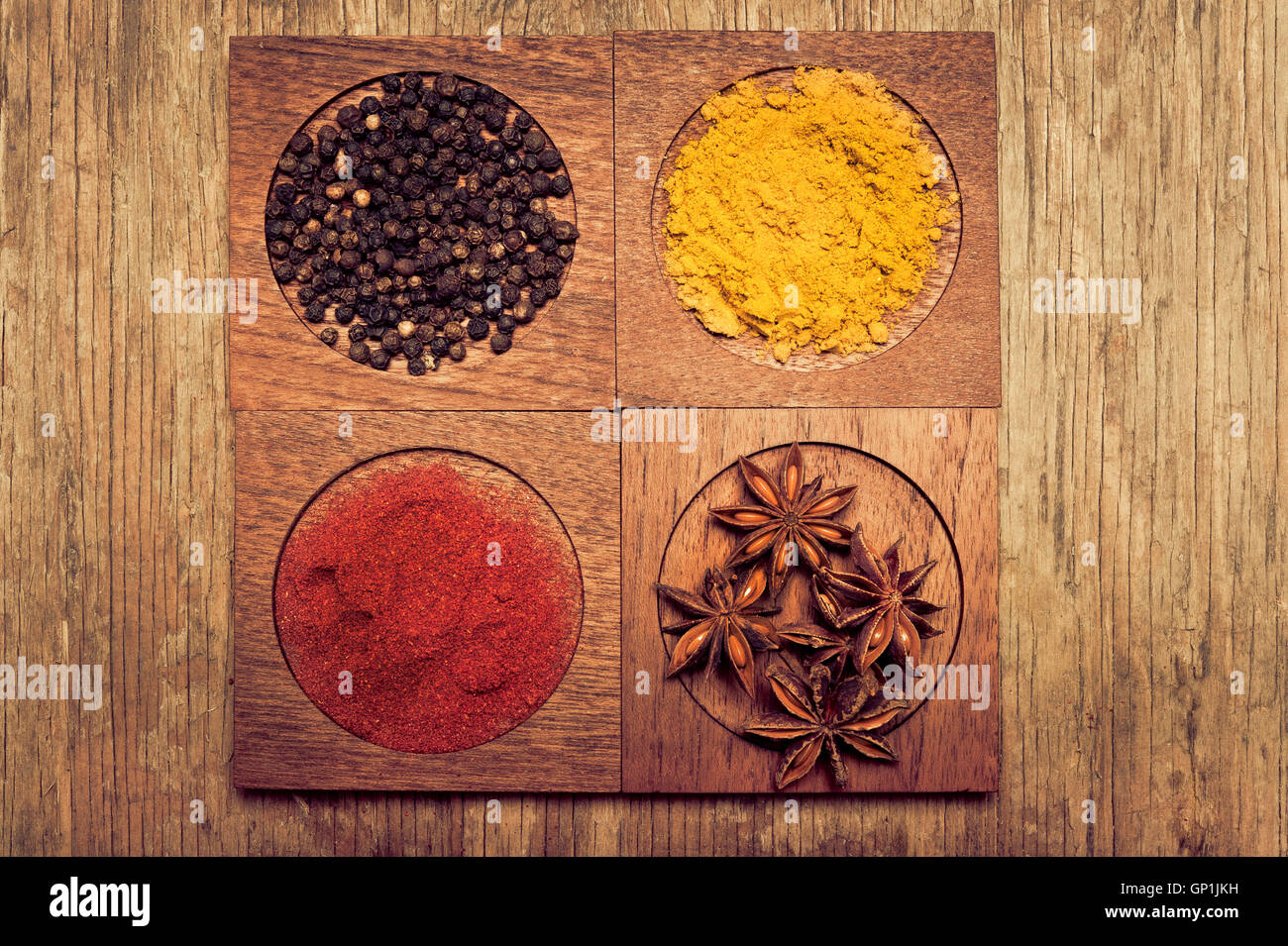 hölzernen Behältern mit Paprika, Pfeffer-Körner, Anis und curry Stockfoto