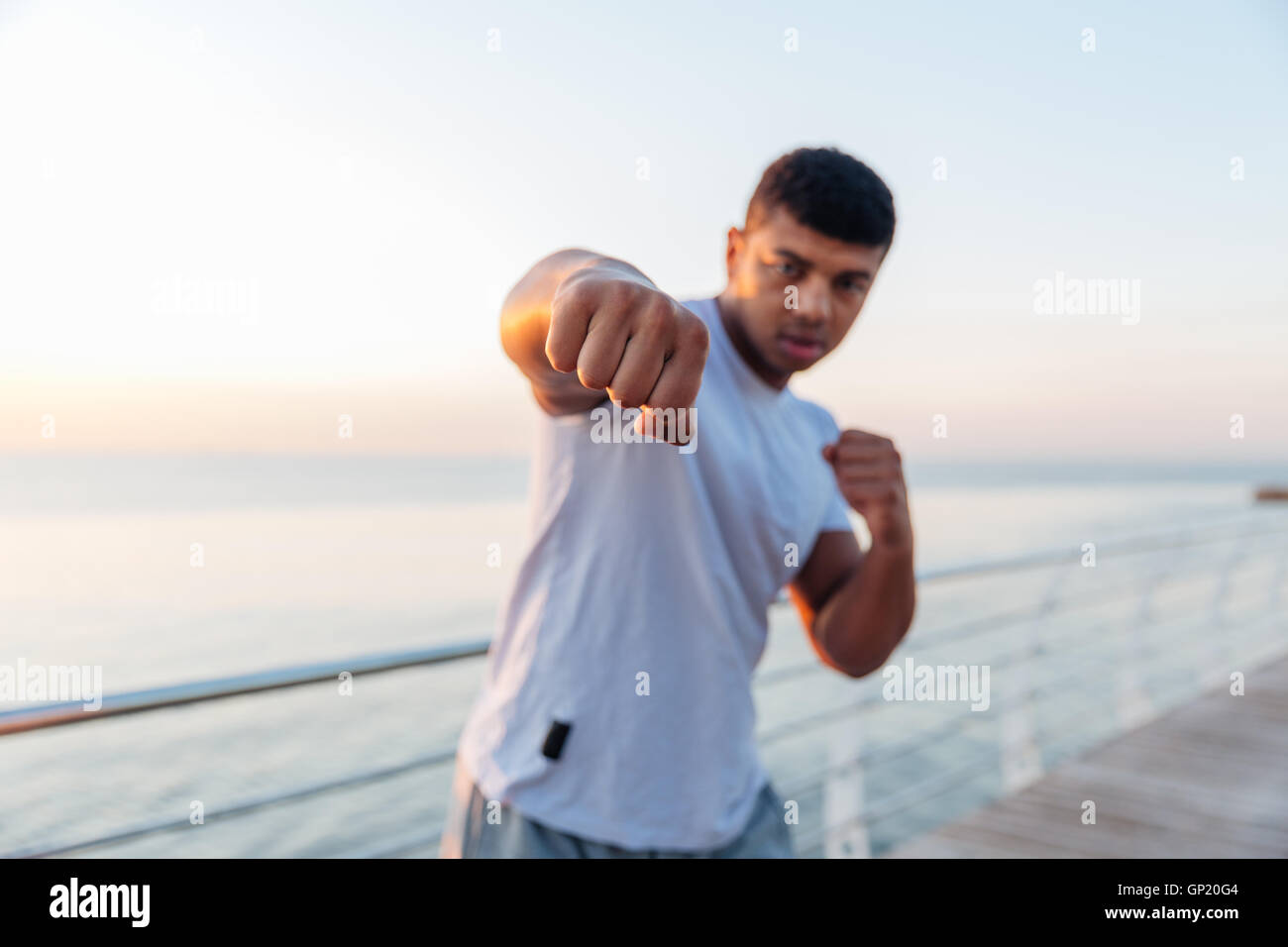 Sportlicher afroamerikanischen jungen Mann Boxer stehen und tun Boxtraining am pier Stockfoto