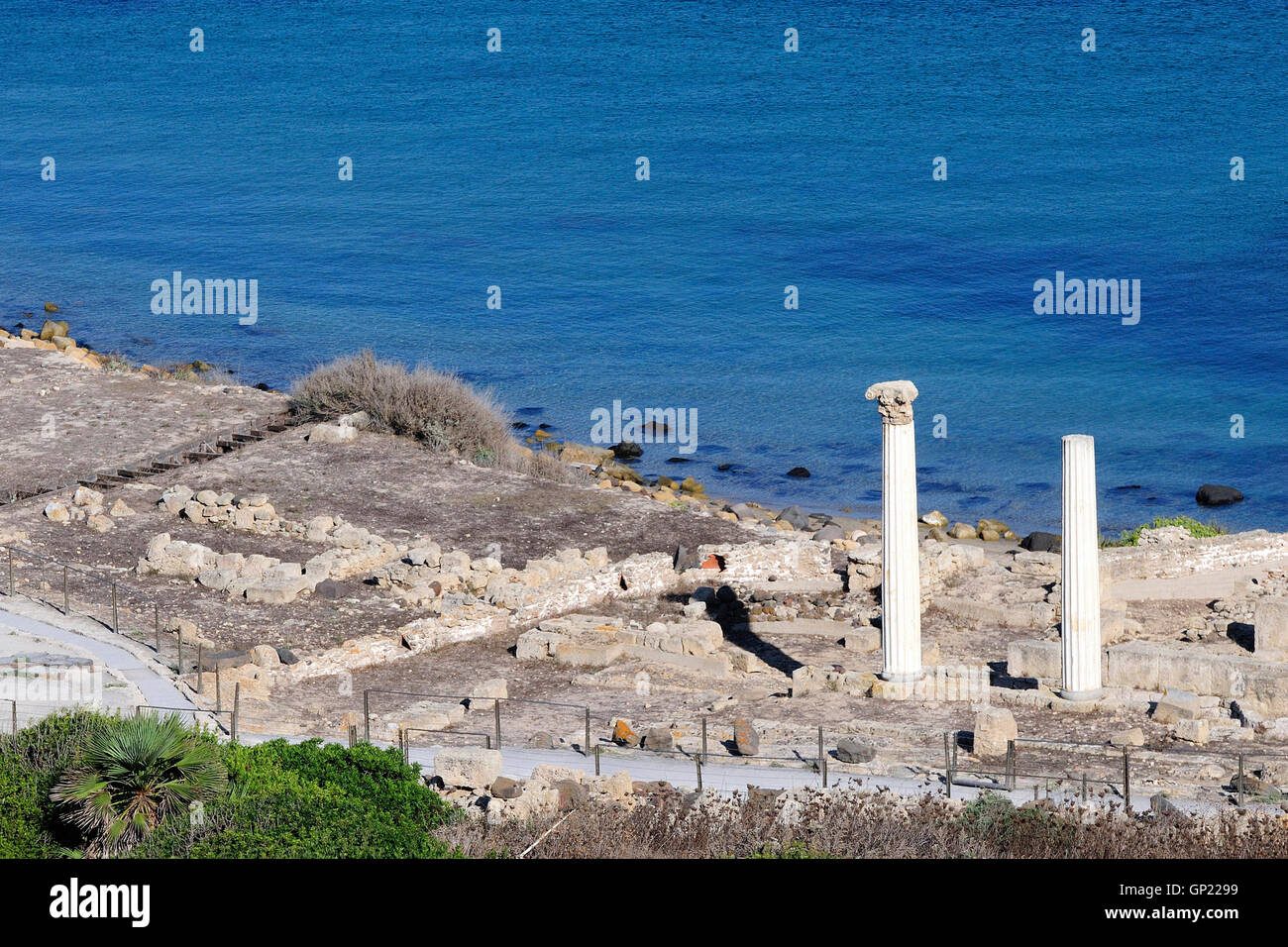 Blick über die Ruinen von Tharros und die Säulen des Tempio Tetrastilo, Sinis-Halbinsel, Sardinien, Italien. Stockfoto