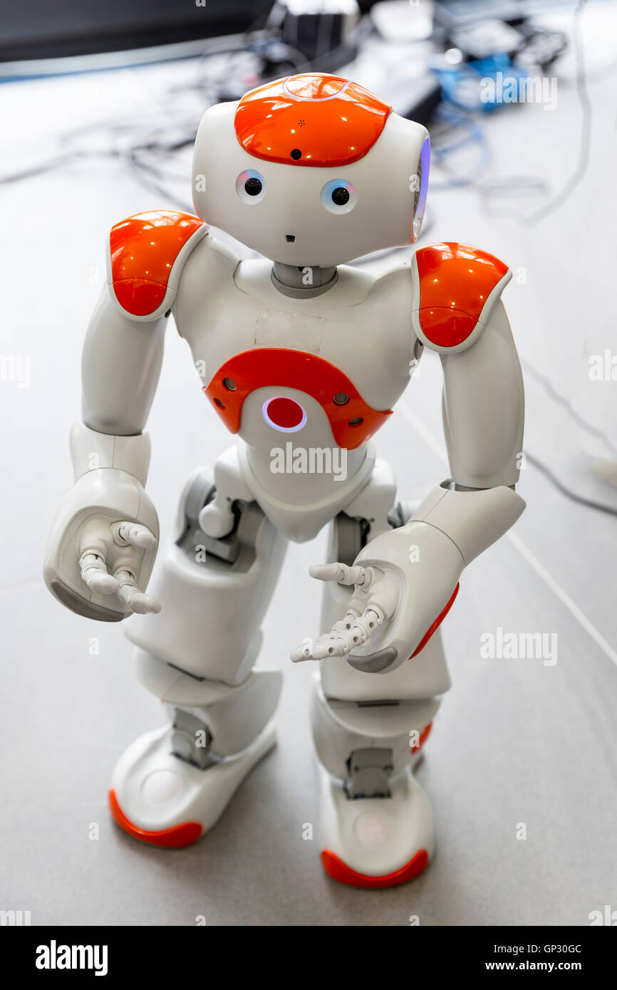 Ein kleiner Roboter mit menschlichen Gesicht und Körper - humanoiden. Künstliche Intelligenz - KI. Orange-Roboter. Stockfoto