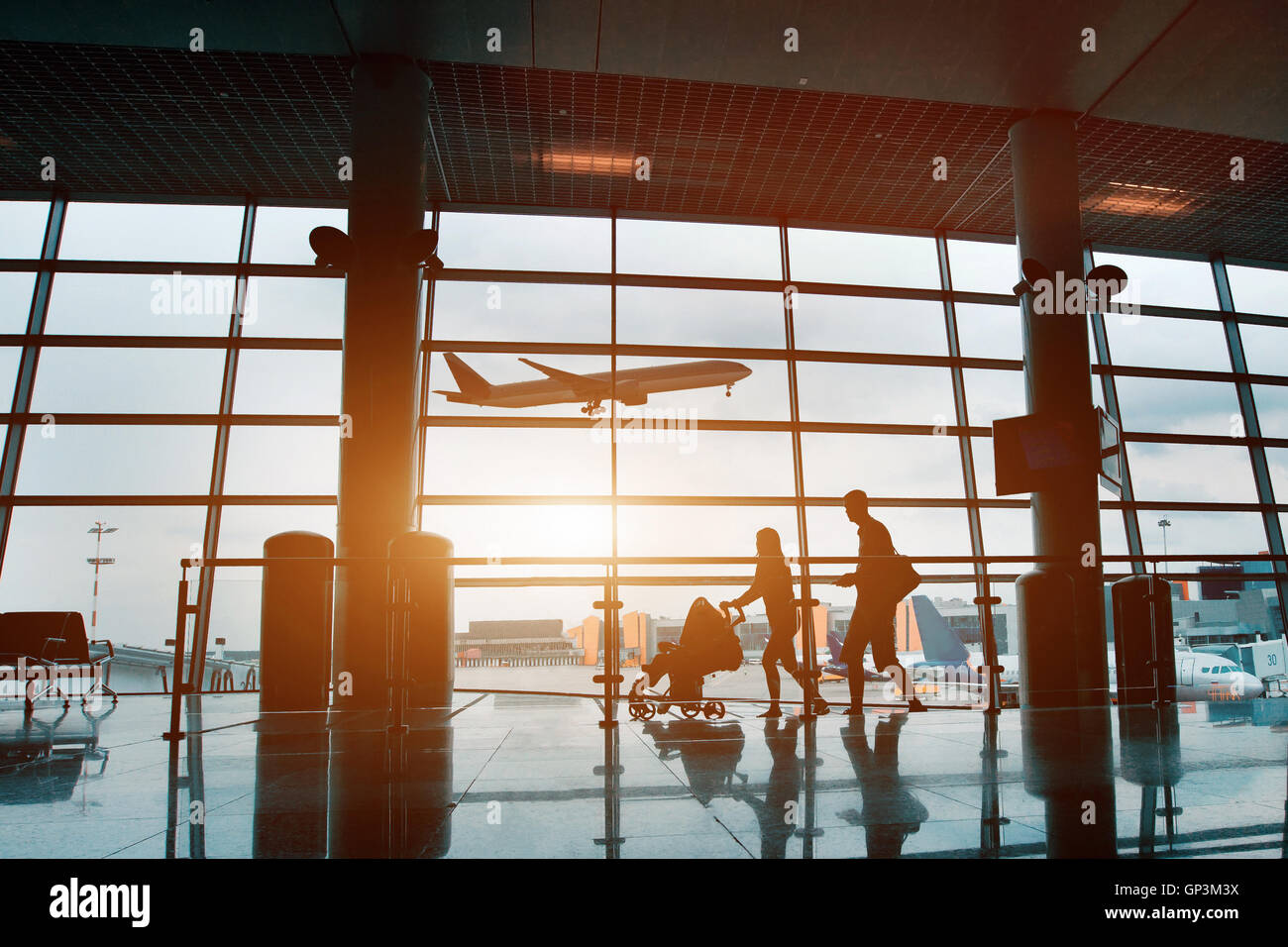 Menschen im Flughafen, Silhouette der jungen Familie mit Baby Reisen mit dem Flugzeug Stockfoto