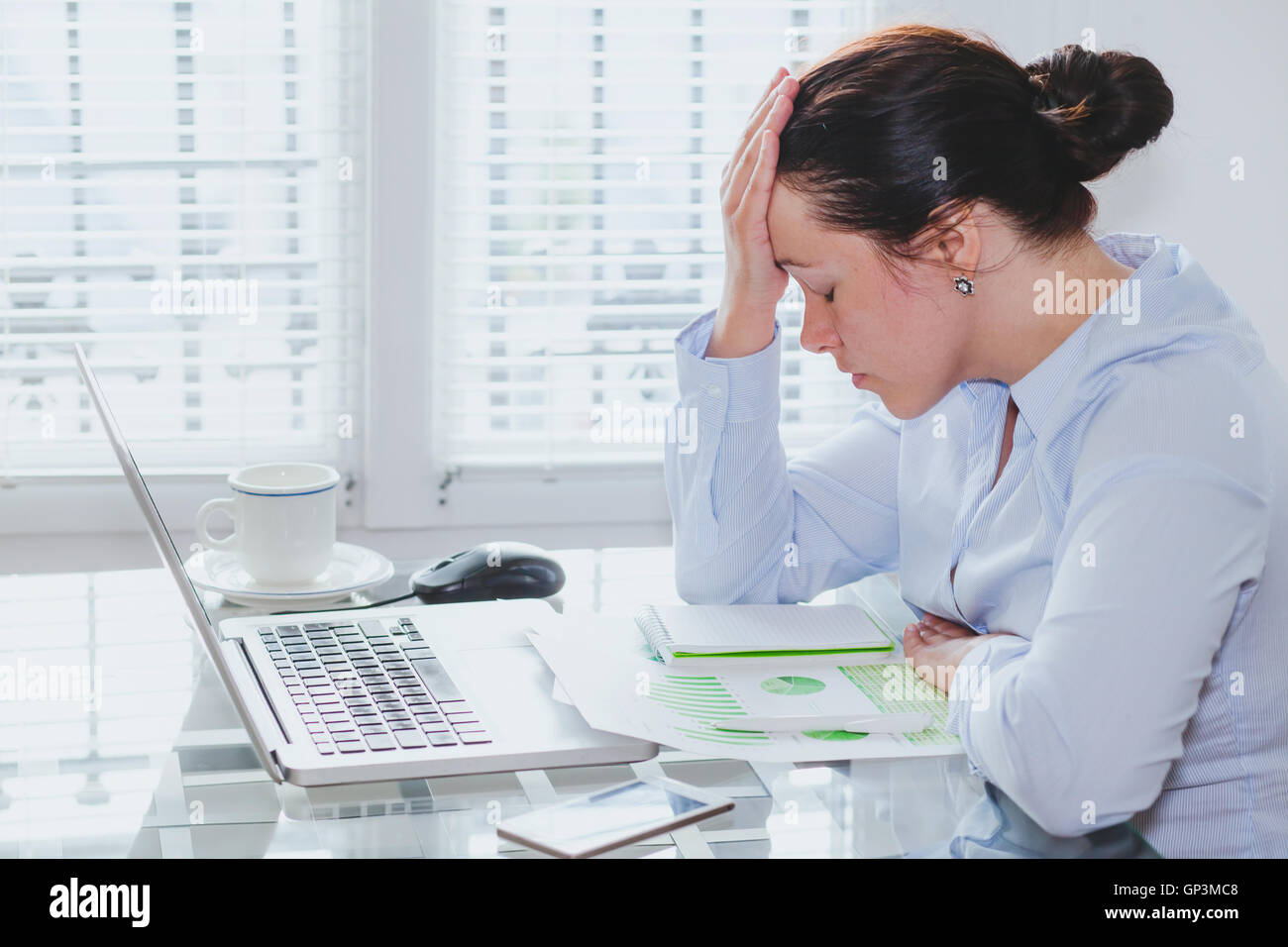 müde Geschäftsfrau mit Computer im Büro, Stress und Probleme, Gefühl Bedauern und schuldig Stockfoto
