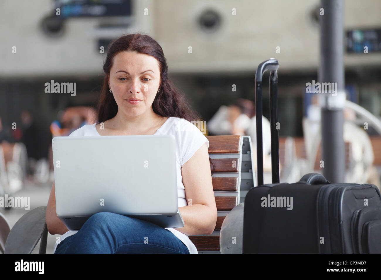 Frau mit Laptop im Flughafen, mit Internet-Anschluss, Reisender, Abrufen von e-Mails Stockfoto