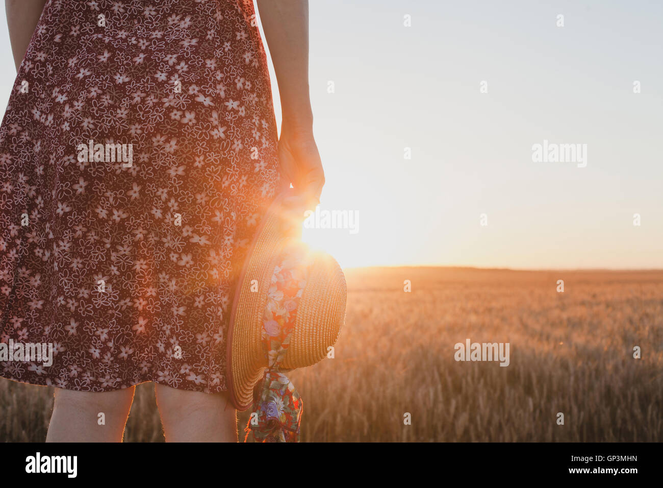 Abschied oder warten Konzept, Sommer Sonnenuntergang, Frau Hand mit Hut Stockfoto