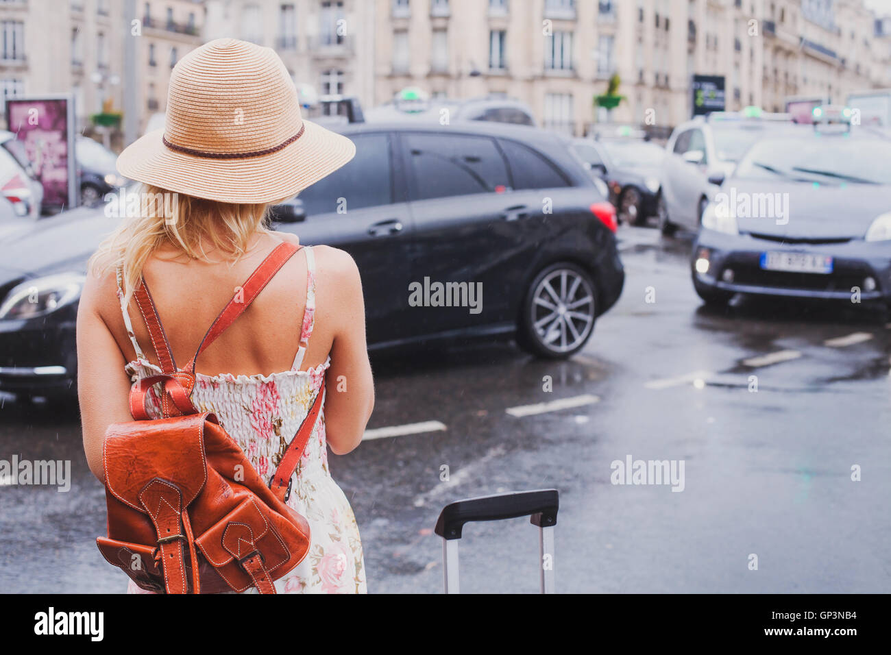 Frau wartet für Taxi, touristische Pendler mit Koffer und Rucksack Stockfoto