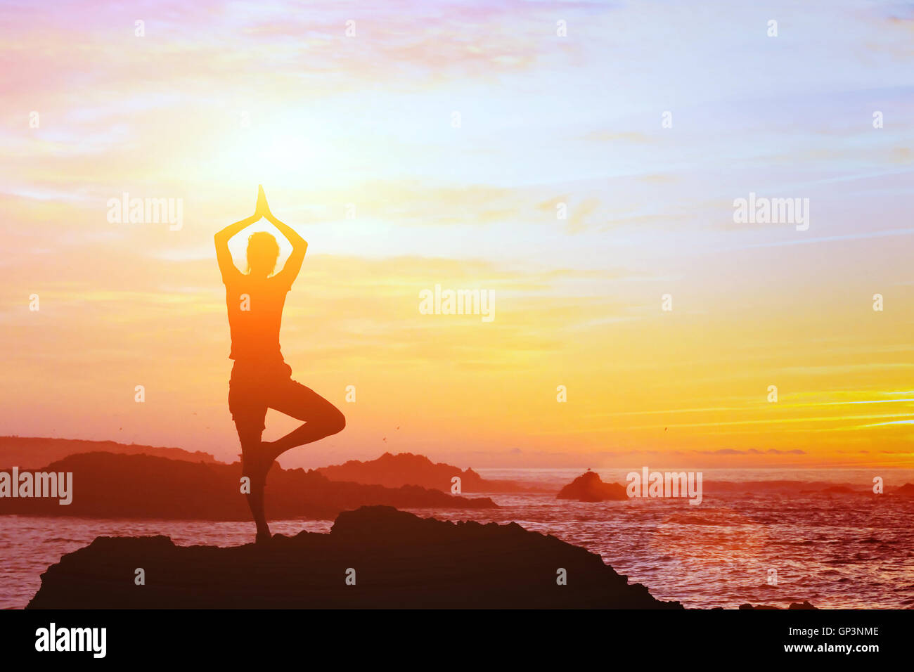 schöne Yoga Hintergrund, Silhouette der Frau am Strand bei Sonnenuntergang, Achtsamkeit Stockfoto
