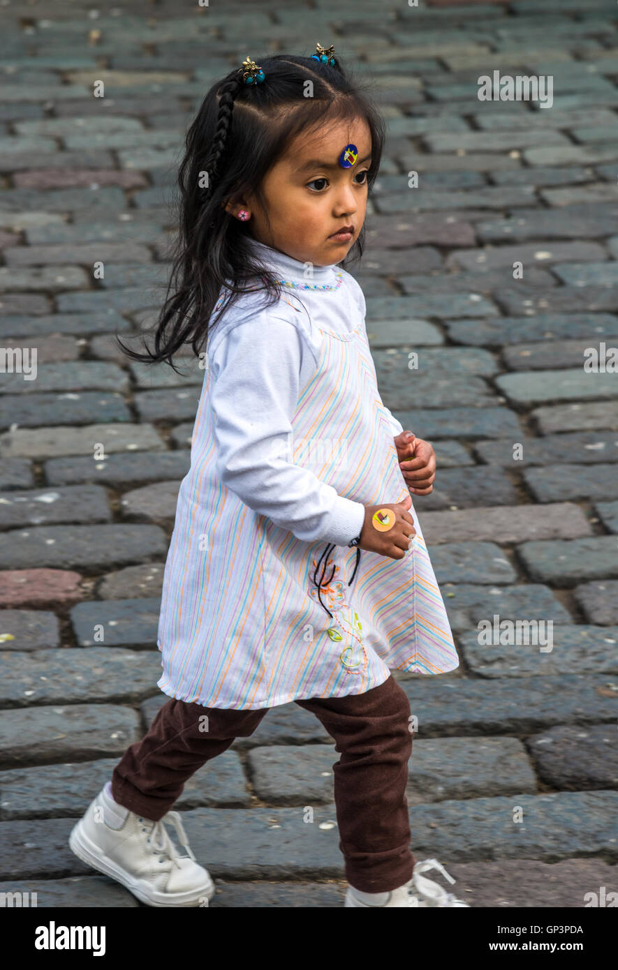 Ein kleines Mädchen läuft auf dem Stein gepflasterten Plaza de San Francisco in der historischen Altstadt Quito, Ecuador. Stockfoto