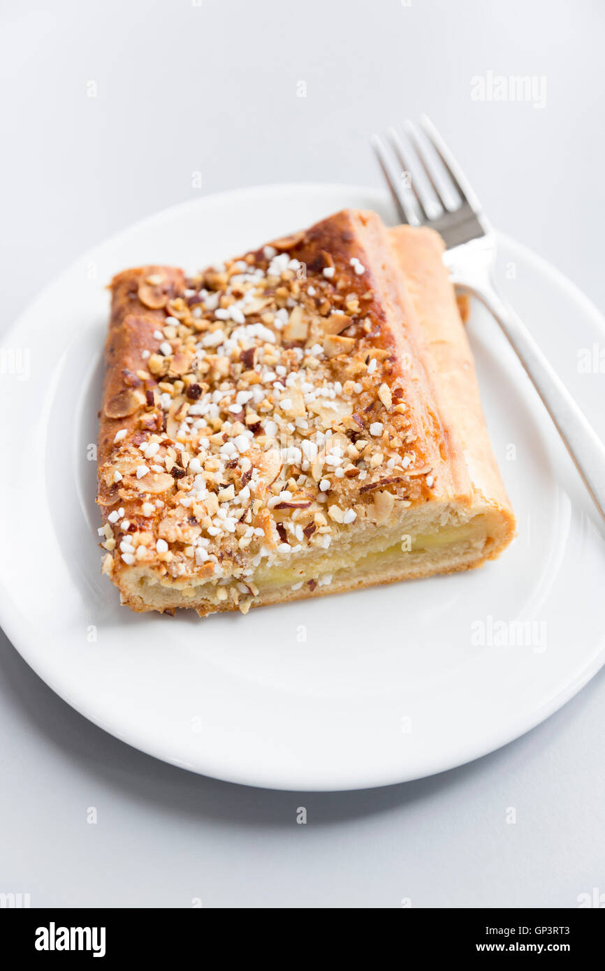 Plundergebäck auf weißen Teller mit Gabel - traditionelle süße Kuchen mit Apfel-Nüssen und Zucker, typische Spezialität Snack Dänemark Stockfoto