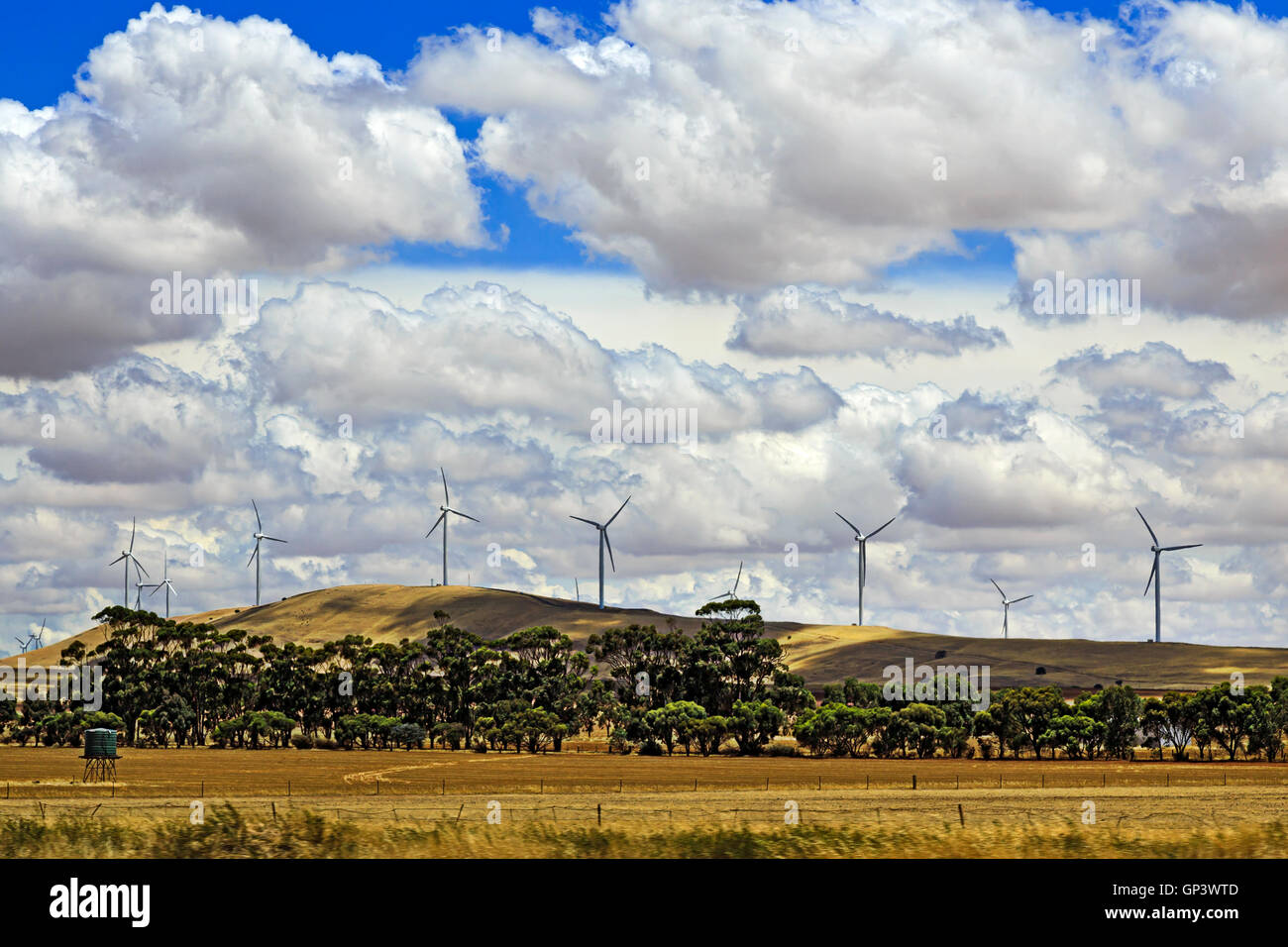 Kette von mächtigen hohen Windturbinen auf Hügelzug in Südaustralien hinter bewirtschafteten landwirtschaftlichen Bereich mit Ernte Stockfoto