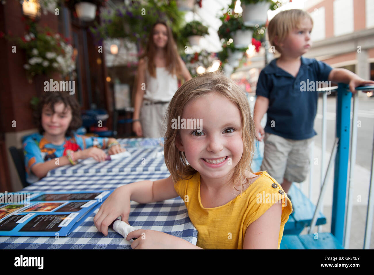 Kleines Mädchen sitzt am Straßencafé, Porträt Stockfoto