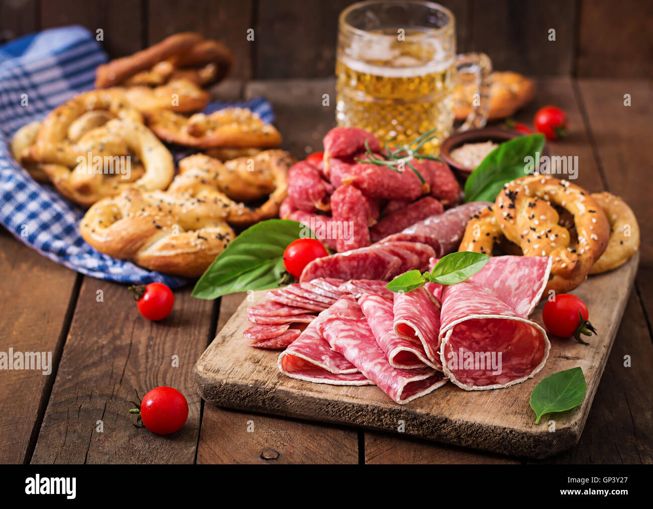 Glas Bier, Brezeln und verschiedene Würste auf hölzernen Hintergrund. Oktoberfest. Stockfoto