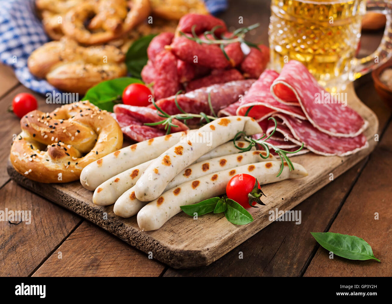 Glas Bier, Brezeln und verschiedene Würste auf hölzernen Hintergrund. Oktoberfest. Stockfoto