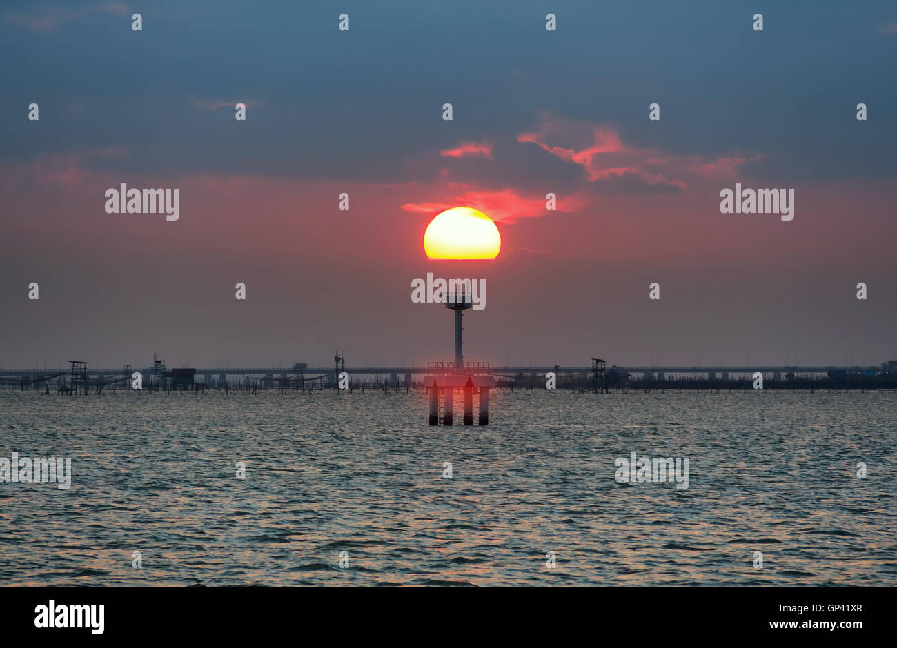 Teilweise bewölkt, Sonnenuntergang Spiegelung Meer. Stockfoto