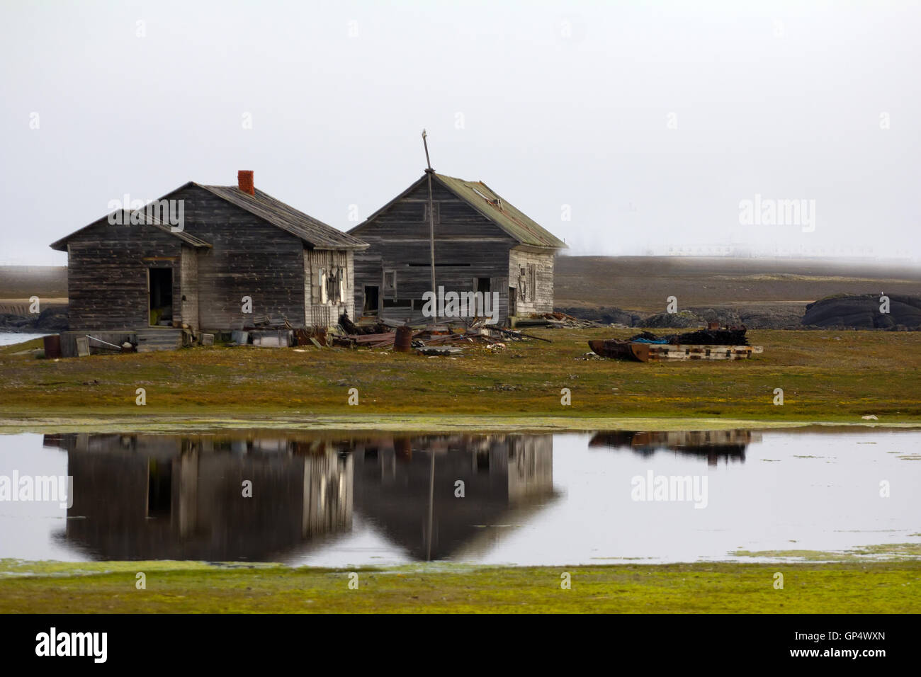 Die Holzbauten Pol der alten Station. Gebäude spiegeln sich im ruhigen Wasser der Lagune Stockfoto