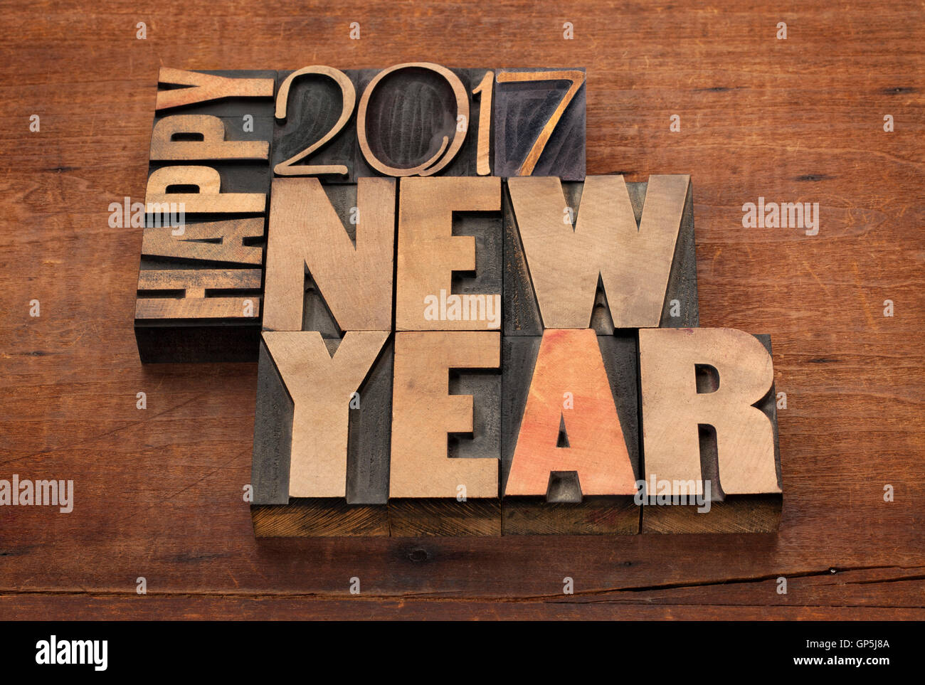Glückliches Neujahr 2017 Grußkarte - Text in Vintage Buchdruck Holzart Blöcken auf einem hölzernen Grunge-Hintergrund Stockfoto